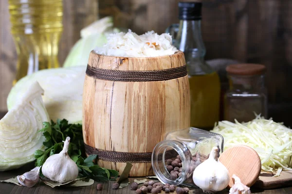 Composition au chou frais et mariné (choucroute) en fût de bois, sur fond de table en bois — Photo