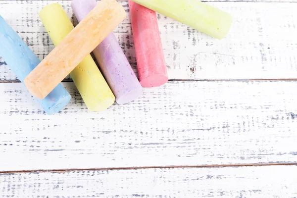 Chalks in variety of colors, on wooden background — Stock Photo, Image