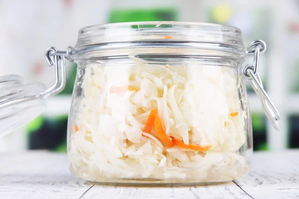 Marinated cabbage (sauerkraut) in glass jar, on wooden background — Stock Photo, Image