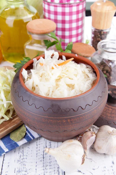 Komposition mit frischem und mariniertem Kohl (Sauerkraut), Gewürzen, auf Holztischhintergrund — Stockfoto