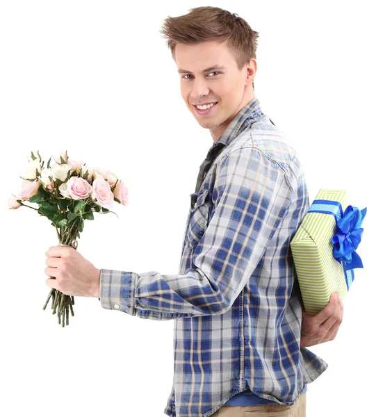 Jovem bonito com flores e presente, isolado em branco — Fotografia de Stock