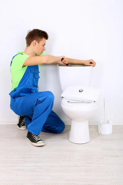 Plumber with toilet plunger on light background — Stock Photo, Image