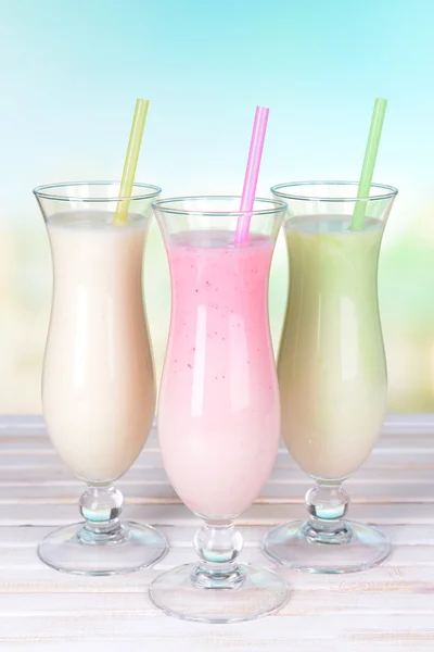 Молочные коктейли на столе на светло-голубом фоне — стоковое фото