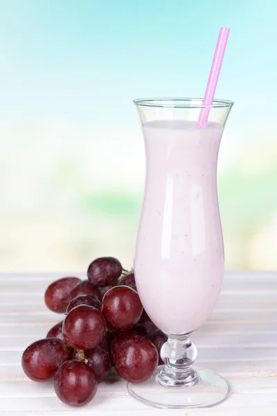 Milk shake on table on light blue background — Stock Photo, Image