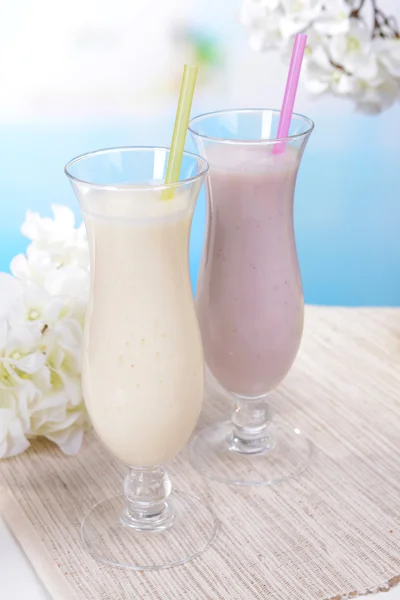 Melk schudt op tafel op lichte blauwe achtergrond — Stockfoto