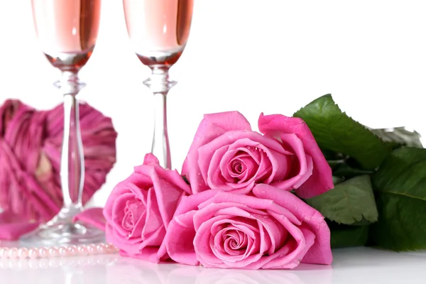 Komposition mit rosa Sekt in Gläsern und rosa Rosen isoliert auf weiß — Stockfoto