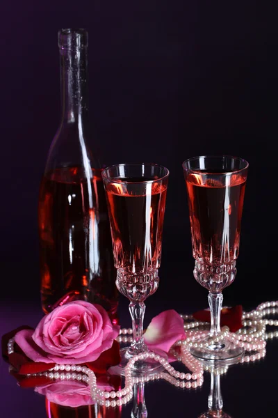 Sammansättning med rosa vin i glas, flaska och rosor på mörk färgbakgrund — Stockfoto