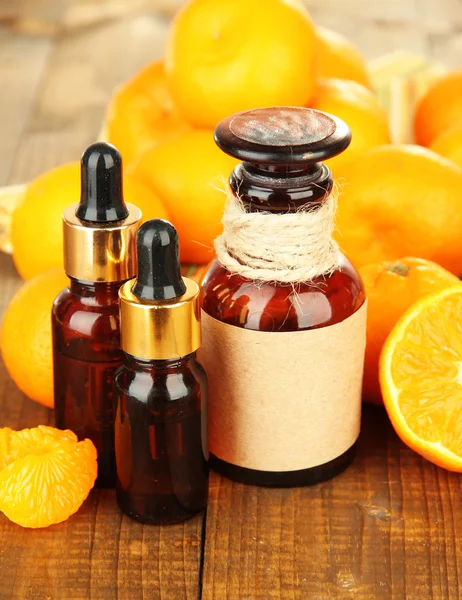 Olejek eteryczny z mandarynek i mandarynki na drewnianym stole — Zdjęcie stockowe