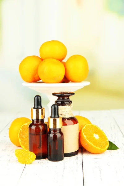 Tangerine essential oil and tangerines on wooden table — Stock Photo, Image