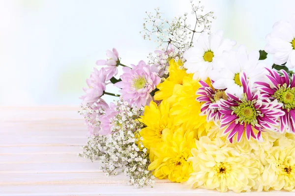 Vackra chrysanthemum blommor på bordet på ljus bakgrund — Stockfoto