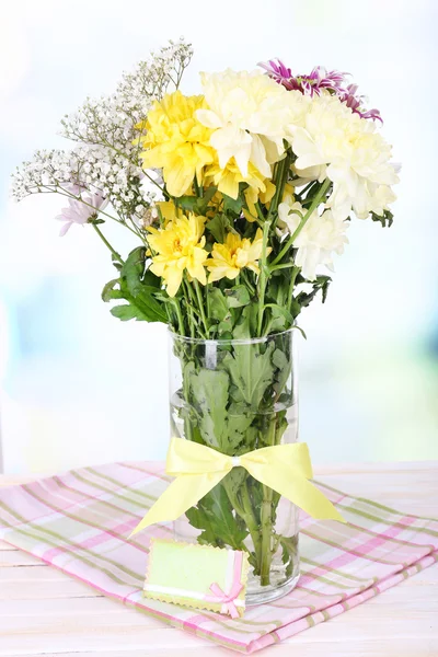 Hermosas flores de crisantemo en jarrón sobre la mesa sobre fondo claro —  Fotos de Stock