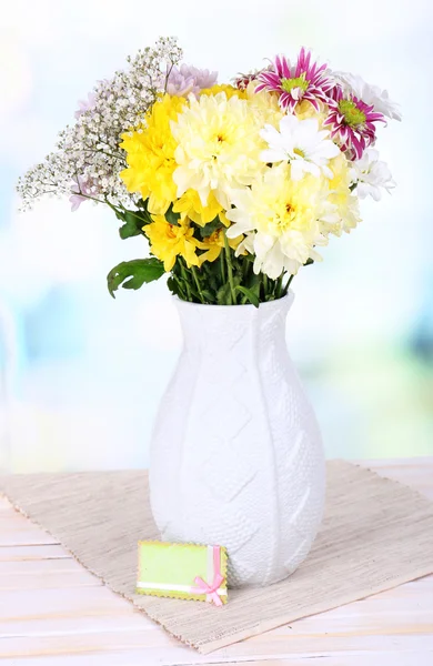 明るい背景上のテーブルの上に花瓶に美しい菊の花 — ストック写真