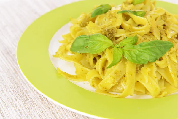 Delicious pasta with pesto on plate on table close-up — Stock Photo, Image