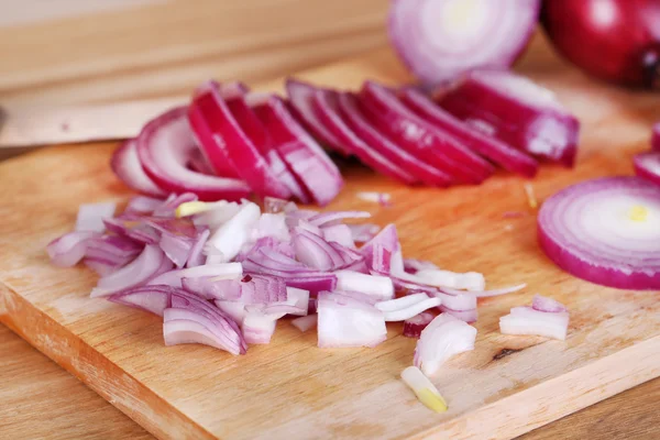 Cipolla tagliata sul tagliere su fondo di legno — Foto Stock