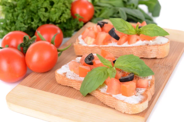 Deliciosa bruschetta con tomates en la tabla de cortar de cerca —  Fotos de Stock