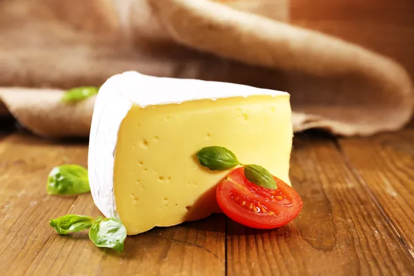 Queijo saboroso Camembert com tomate e manjericão, sobre mesa de madeira — Fotografia de Stock