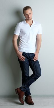 Genç manken, gölge ile duvarın üzerinden poz veriyor