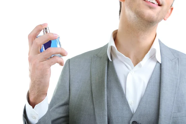 Beau jeune homme utilisant un parfum isolé sur blanc — Photo