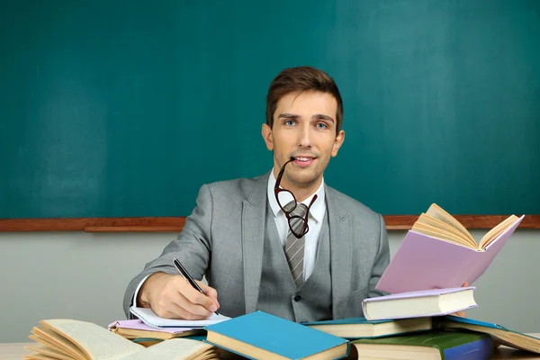 Young teacher sitting in school classroom — Stock Photo, Image