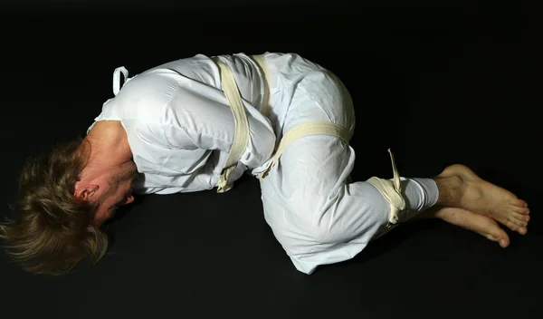 Hombre mentalmente enfermo con camisa de fuerza sobre fondo negro —  Fotos de Stock