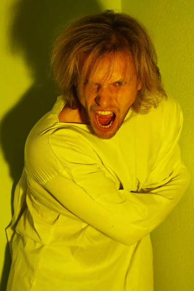 Mentally ill man in strait-jacket in room corner — Stock Photo, Image