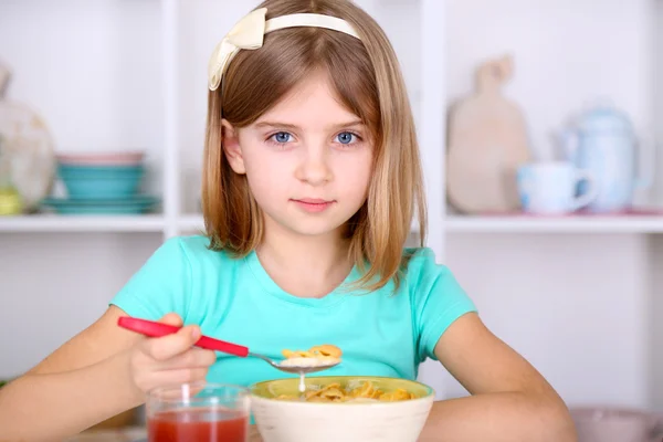 Beautiful little girl eating breakfast in kitchen at home — Stock Photo, Image