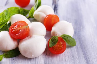 ahşap masa üstünde domates ve fesleğen ile lezzetli mozzarella peyniri