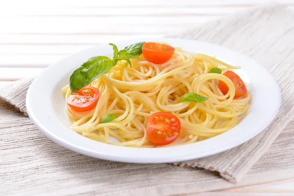 Leckere Spaghetti mit Tomaten auf dem Teller in Großaufnahme — Stockfoto
