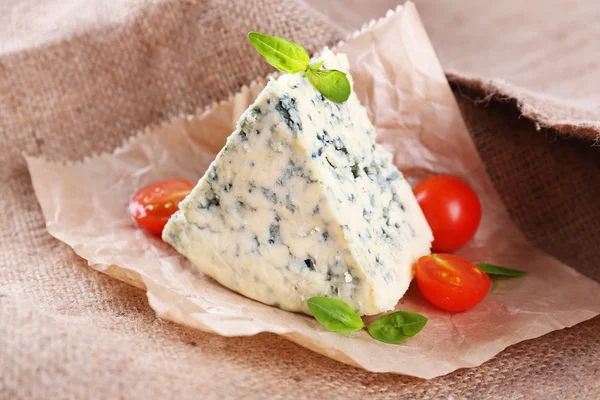 Tasty blue cheese with tomatoes and basil, on burlap background — Stock Photo, Image