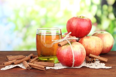 Olgun elma tarçın ve apple içki parlak zemin üzerine ahşap masa üzerinde bardak