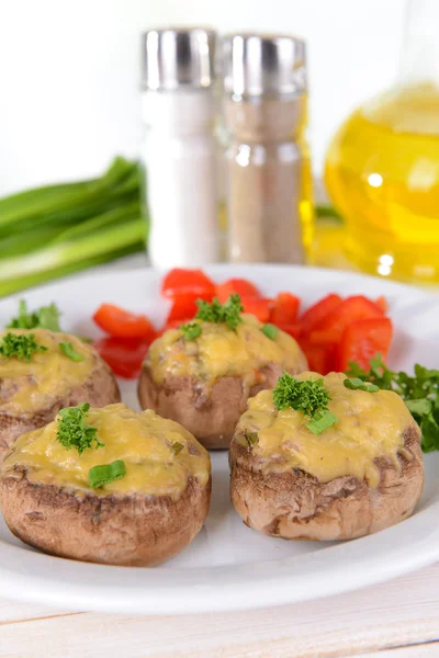 Stuffed mushrooms on plate on table on light background — Stock Photo, Image