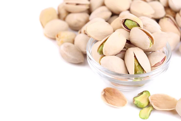 Pistachio nuts in glass bowl isolated on white — Stock Photo, Image
