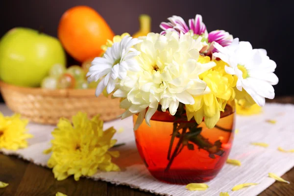 Beautiful chrysanthemum flowers in vase on table on dark background — Stock Photo, Image
