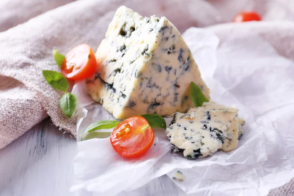 Sabroso queso azul con tomates y albahaca sobre papel — Foto de Stock