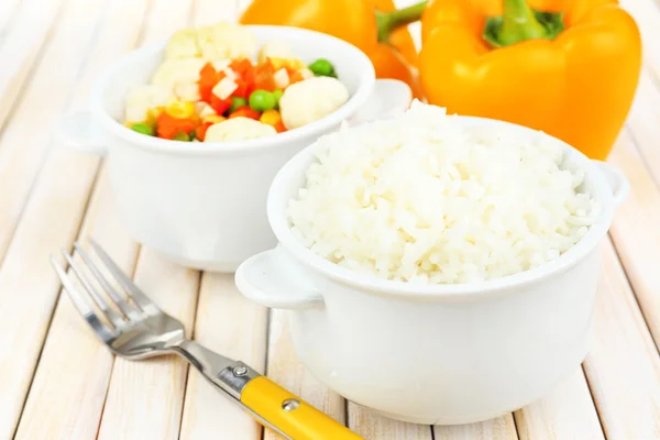 Gekookte rijst met groenten op houten tafel close-up — Stockfoto