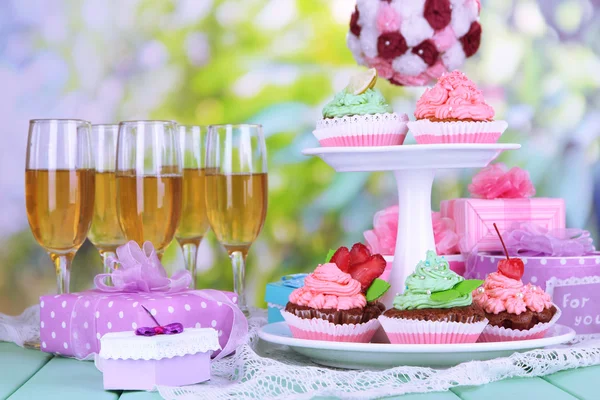 Utsökt vackra cupcakes på festliga bord på naturliga bakgrund — Stockfoto