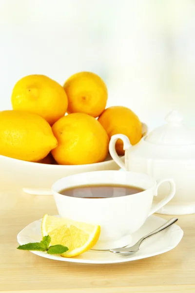 Cup of tea with lemon on table on light background — Stock Photo, Image