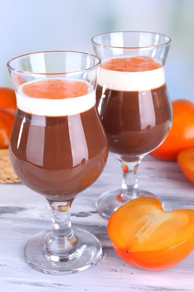 Dessert aus Schokolade und Kaki auf dem Tisch vor hellem Hintergrund — Stockfoto