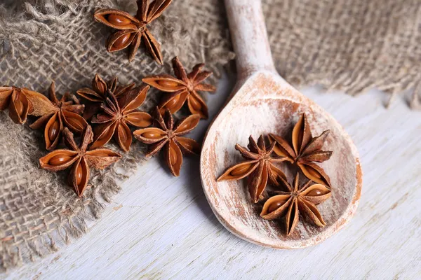 Anice stellato in cucchiaio di legno, su fondo di legno — Foto Stock