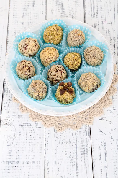 Set Schokoladenbonbons, auf Teller, auf Holzgrund — Stockfoto