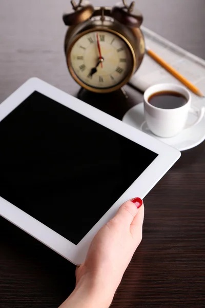 Tablett, tidning, kopp kaffe och väckarklocka på träbord — Stockfoto