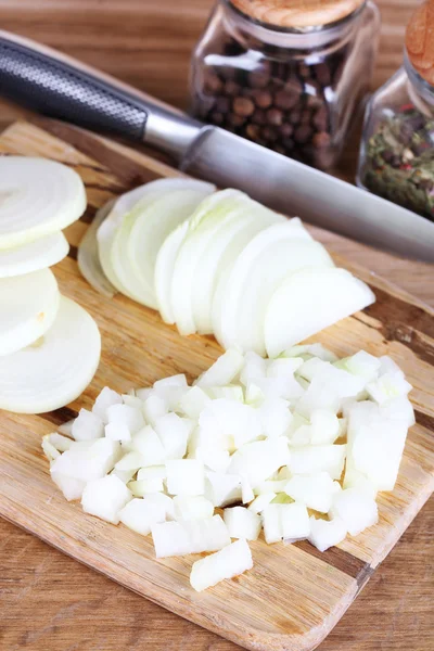 Geschnittene Zwiebel auf Schneidebrett auf Holzgrund — Stockfoto