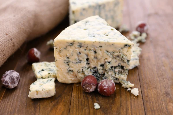 Tasty blue cheese with nuts, on wooden table — Stock Photo, Image