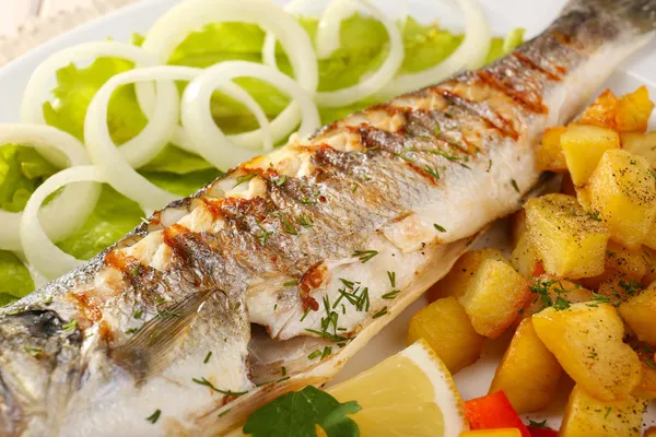 Delicious grilled fish on plate on table close-up — Stock Photo, Image