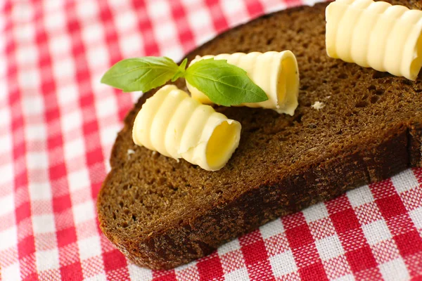 Rebanada de pan de centeno con mantequilla, sobre mantel —  Fotos de Stock