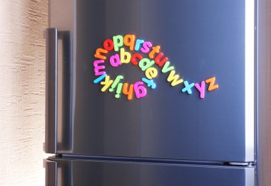 buzdolabı üzerinde renkli mıknatıslı harfler