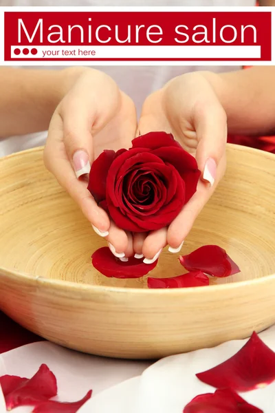 Mani donna con ciotola di legno di acqua con petali da vicino — Foto Stock