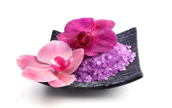 Hermosas flores de orquídea en flor y un montón de sal marina en el plato, aislado en blanco —  Fotos de Stock