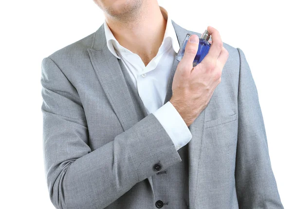 Joven guapo usando perfume aislado en blanco — Foto de Stock