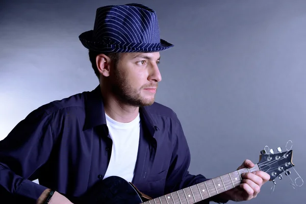 젊은 음악가 재생 어쿠스틱 기타와 노래, 회색 바탕에 — 스톡 사진